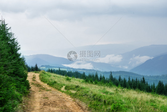 山中乡间公路在一片阴云的天空下山上乡间公路空的森林绿色图片