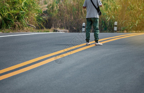 穿着运动鞋的男子在街上走着黄线路条男人图片