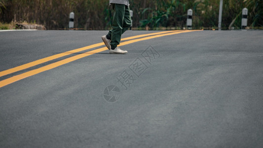 积极的穿着运动鞋男子在街上走着黄线脚丫子户外图片