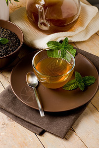 照片木桌玻璃杯中美味的绿色薄荷茶木制的消化甜点图片