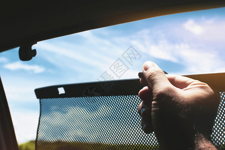 遮阳伞司机举起车边窗帘的遮太阳罩保护光里面织物图片