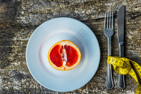 水果吃健康食品概念配有切葡萄汁和木制桌上测量的板块银器图片