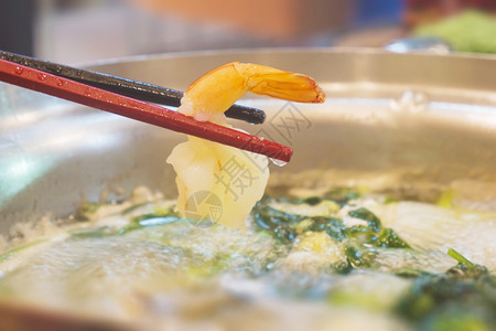 烹饪好吃火辣苏kiyaki锅里有虾的筷子高清图片