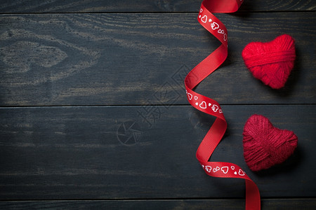红色的心用木背景上的羊毛做成红心供华伦人日使用针织木头图片