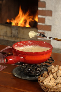 萨姆纳斯面包被浸入甜美碗里熔化的奶酪中食物锅图片
