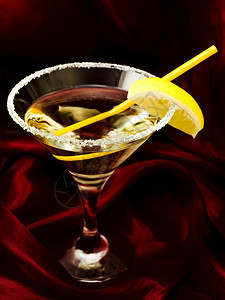 酒精透明和柠檬鸡尾酒对着丝绸液体图片