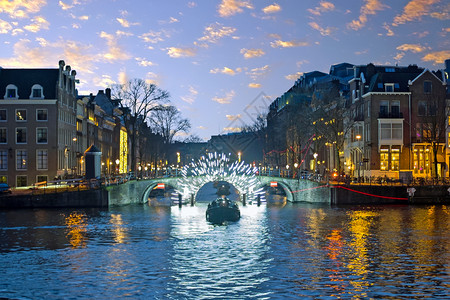 首都建筑学日落时荷兰阿姆斯特丹河市中心的阿姆斯特丹灯光海浪图片