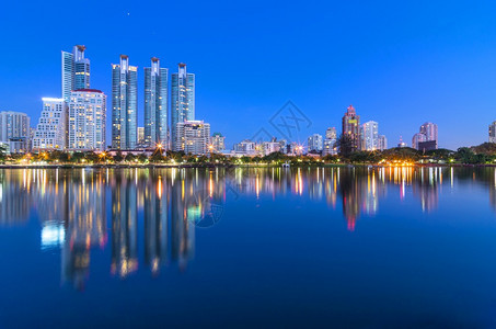 反射曼谷市中心晚上在反映天空线的城市风景公寓塔图片