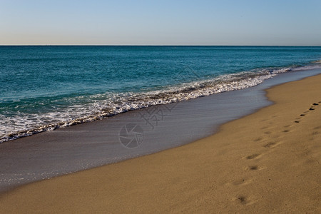 海景滩潮水在金沙上滚落阳光图片