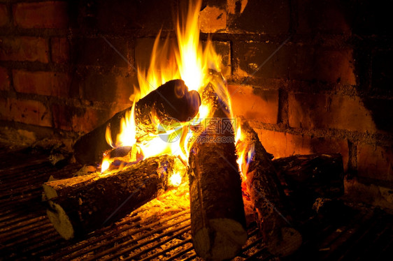 加热温暖的在壁炉中燃烧圆木以制砖壁钢坯图片