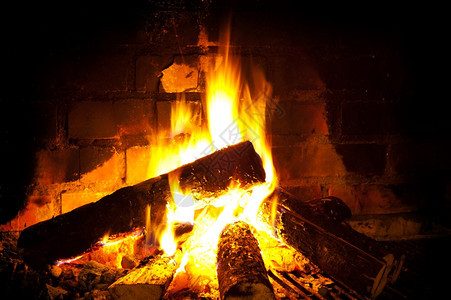 加热在壁炉中燃烧圆木以制砖壁水平的温暖图片
