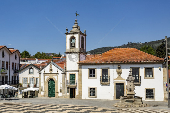 正方形房子在葡萄牙阿韦伊罗鲁卡市公民中心的圣慈悲之家和前市议会教堂的对面并肩驻扎在葡萄牙阿维罗鲁卡市的公民中心寺庙图片
