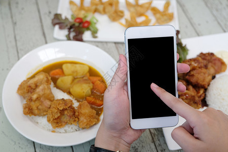 送货手用智能电话对模糊食物背景拟板在线食物和交付概念空白屏幕的智能手机使用应程序网络图片