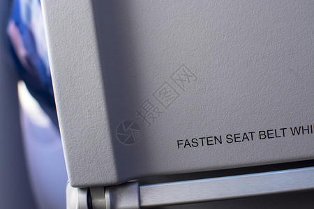 金属背部带文字系紧安全的飞机内部座椅靠背的特写带文字系紧安全的飞机内部图片