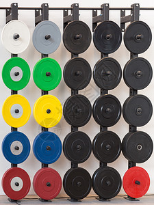 健身房各种颜色的健身杠铃铁重量板各种颜色的健身杠铃铁重量板盘子合身图片