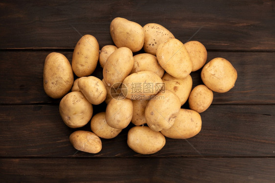 生的丰富营养木桌上的一组新土豆顶视图图片