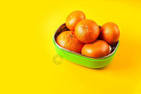 黄色背景的绿午餐盒里天然柑橘色热带盒子多汁的图片