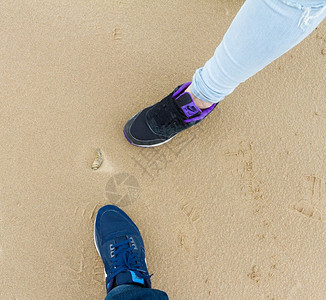 鞋类在英国布莱克普尔的男孩和女腿运动鞋和沙上海壳星滩图片