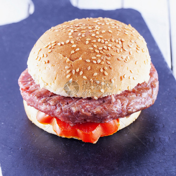 正方形一顿饭午餐汉堡三明治和番茄加黑石头切碎板的平方图象图片