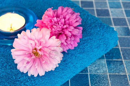 浴室瓷砖上的蜡烛毛巾和花朵图片