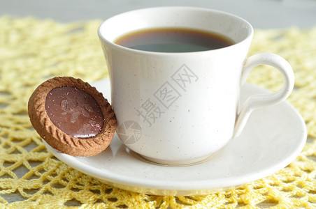 一个茶杯和圆饼干展示在编织布上甜点巧克力种类图片