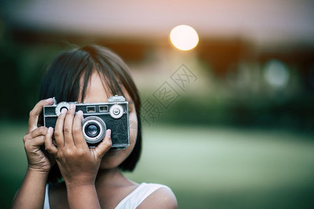 年轻的蝴蝶公园可爱小女孩用反光照相机拍片图片