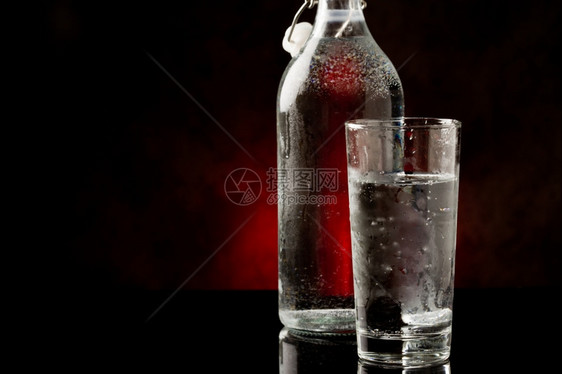 口渴反射生活黑色玻璃桌上的水杯和瓶子相照片图片