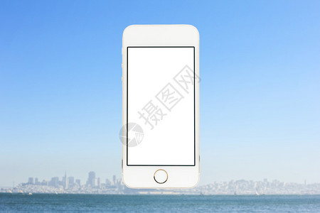 展示互联网模糊的城市海天和背景的移动电话便携图片