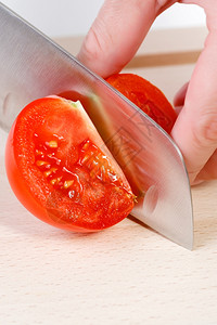 蔬菜新鲜的锋利女用刀砍手切新鲜红西番茄图片