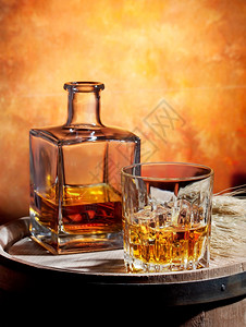 饮料优雅瓶装威士忌和一杯在木桶上加冰威士忌酒图片