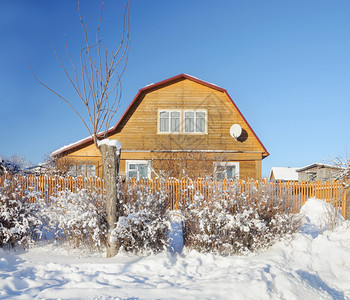 木制的冬天居住地俄罗斯阳光明媚的寒冬日带曼沙德的乡村木屋图片