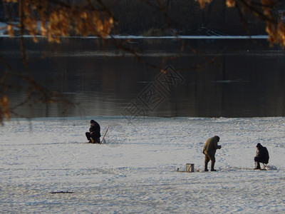 渔夫民坐在冰上河钓鱼自然湖图片