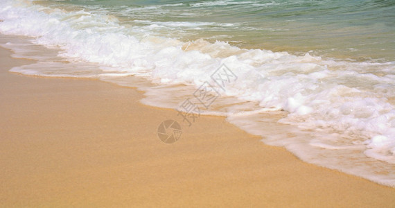 质地关闭金沙滩和海浪的绿水热滩图片