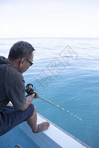 漂浮在蓝色海水上的船只捕鱼男子自然沿海岸图片