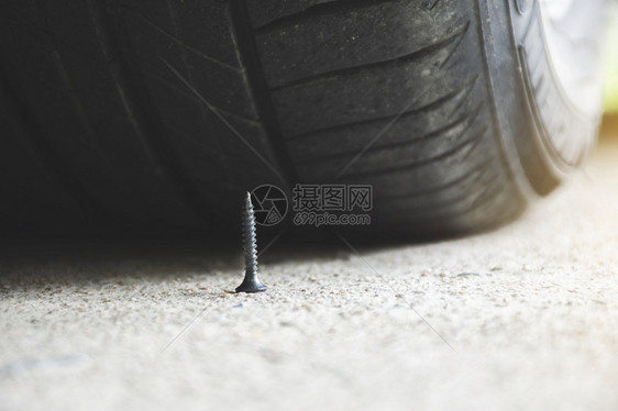 近乎刺穿汽车轮胎的路上紧贴着尖利金属螺丝别针橡胶指甲图片