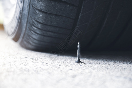 踏驾驶近乎刺穿汽车轮胎的路上紧贴着尖利金属螺丝橡胶图片