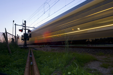 灯黄昏刚过后火车高速通过铁路交叉口电线速度图片