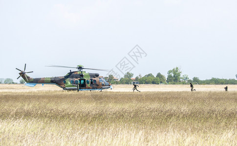 武装参加以直升机作战和冲突构想进行军事演习的救援军事行动的士兵有直升机战争和冲突概念天空训练图片