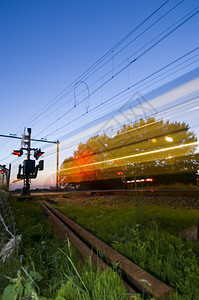 一列火车在夜间通过铁路境点运动城际栅栏图片