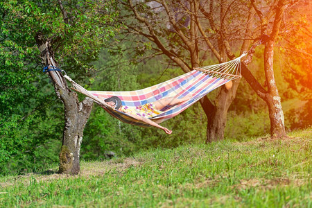 快乐的自然户外女人睡在夏日的吊床上图片