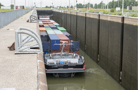 弓Maas河中的货船锁在Holland货物商业的图片