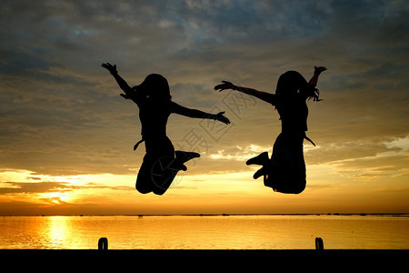 喜悦美丽的日落背景在海上跳的妇女轮光影夏天乐趣图片
