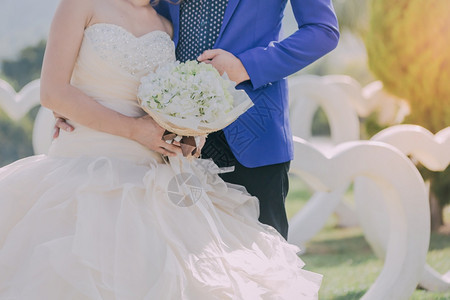 户外新娘和郎亲手牵在婚礼当天握一束美丽的花可爱男图片