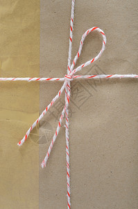 纸空白的棕色邮包裹装的递送与白色背景上的字符串和粘附胶带捆绑在一起工艺图片