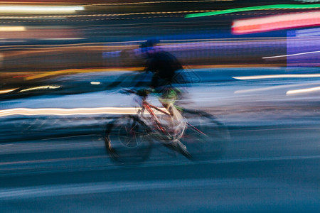 匆忙路超车在模糊的城市景象中骑自行车的人图片