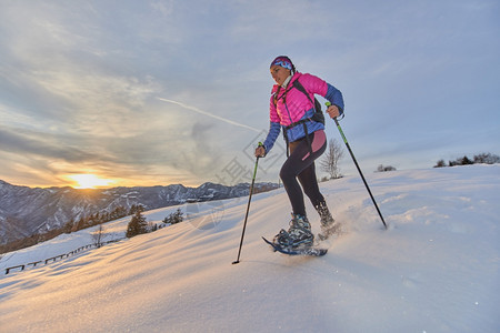 远足山上日落时的风景女孩带着雪鞋下山白色的季节图片