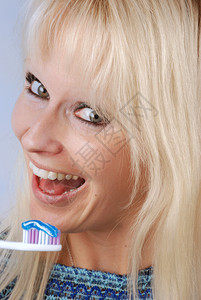 肖像牙齿白色的年轻金发美女刷牙人图片