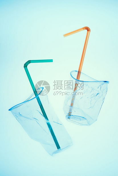 蓝色背景上压扁的塑料杯和吸管收集塑料垃圾以回收污染和过多垃圾的概念顶部复制空间处理家庭杯子图片