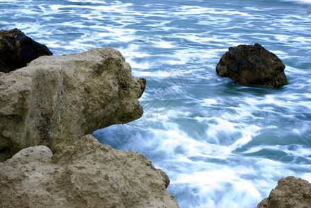 蓝色的波纹海景拉夫达黑岸的石图片