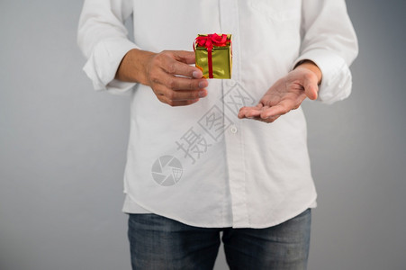 鸡毛菜鸡毛菜包裹男人手持礼品箱新年圣诞节鸡毛年生日概念庆祝设计